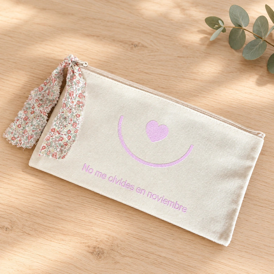 Neceser solidario Singular con mensaje No me olvides en noviembre y lazo floral sobre madera clara