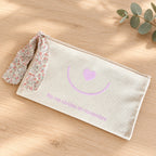 Neceser solidario Singular con mensaje No me olvides en noviembre y lazo floral sobre madera clara
